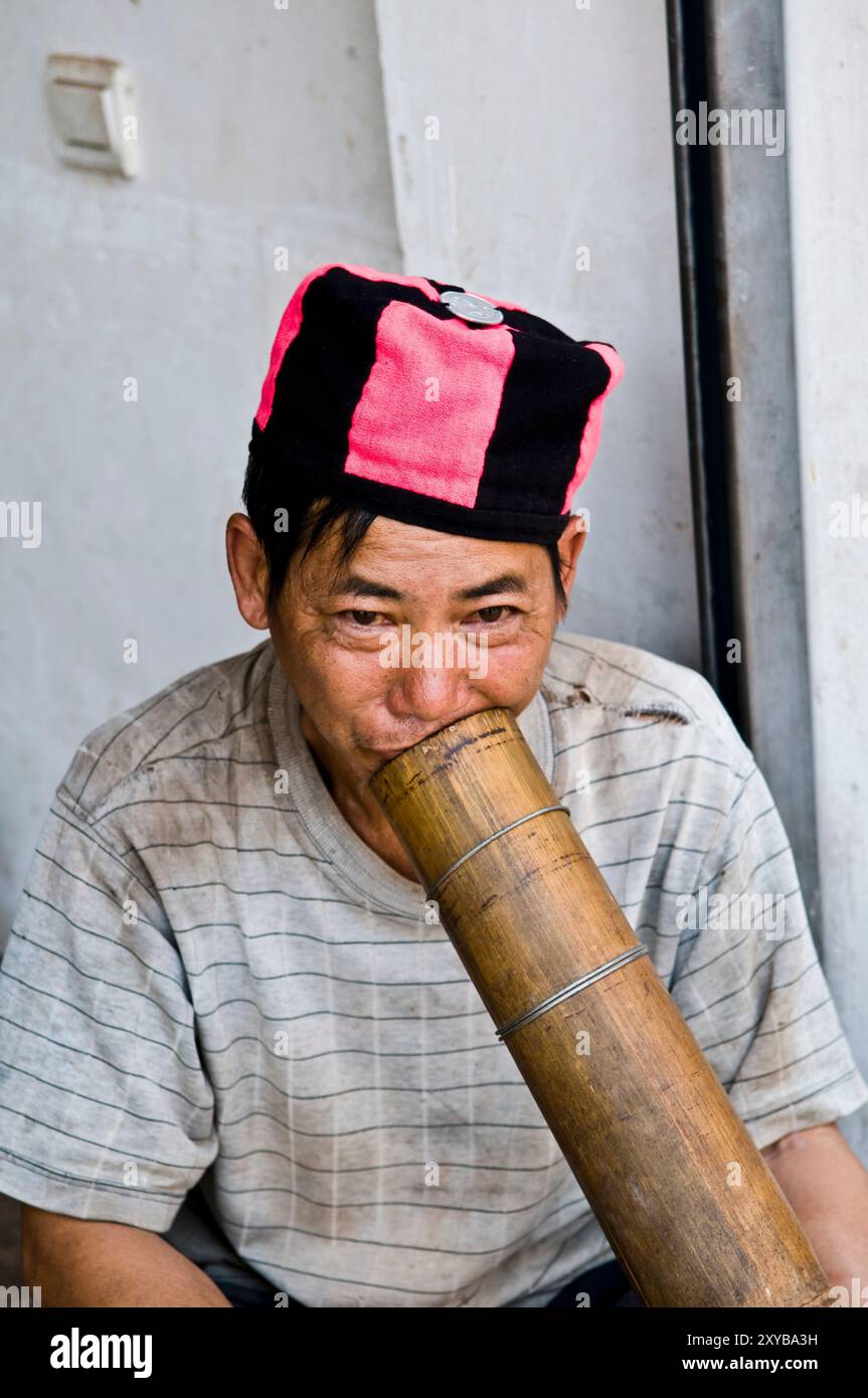 Rauch am Nachmittag mit einer traditionellen Bambuspfeife. Foto auf dem Laomeng Wochenmarkt in der südlichen Provinz Yunnan, China. Stockfoto