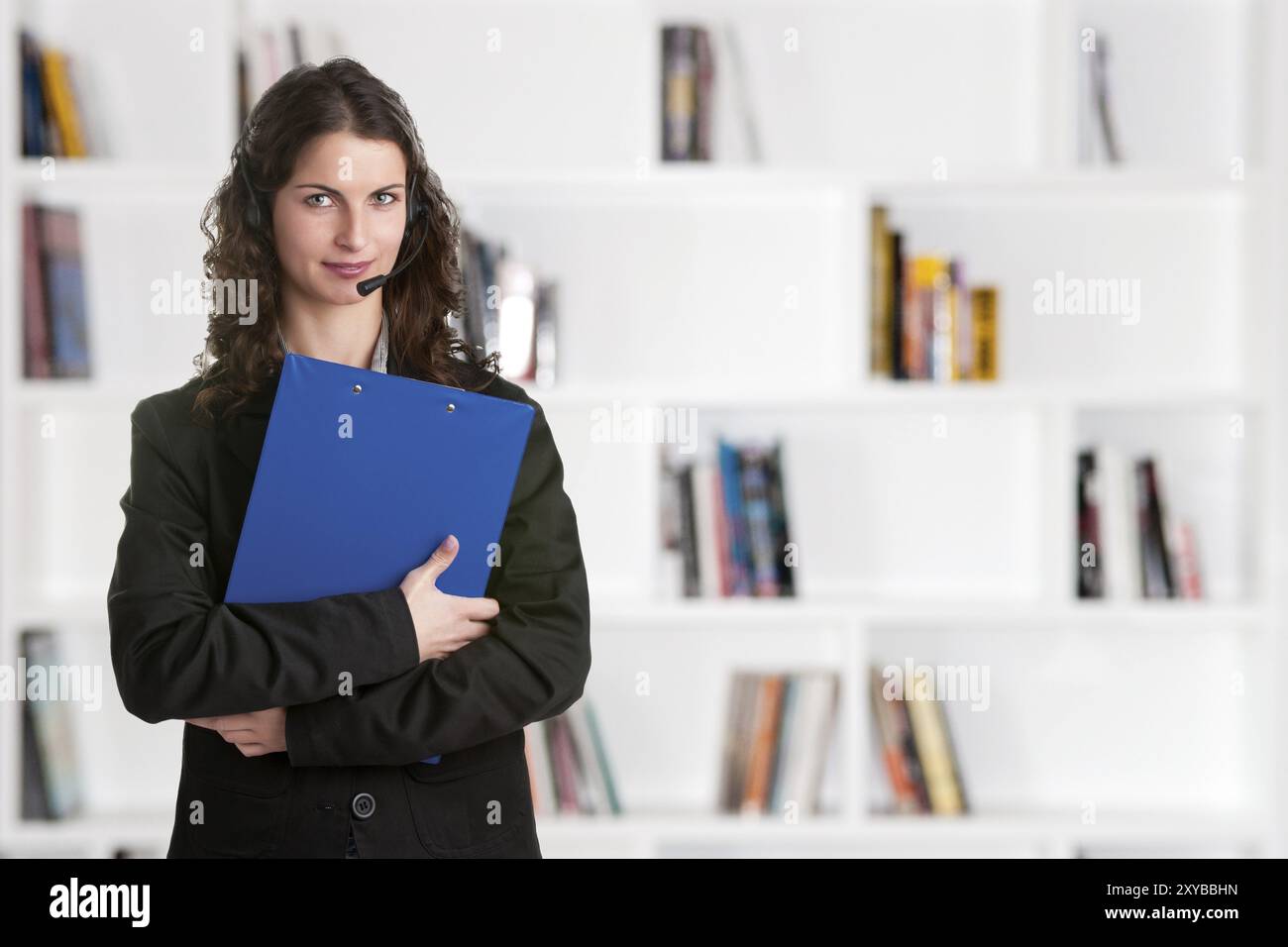 Corporate Frau sprechen über ihre Kopfhörer mit einem blauen pad Stockfoto