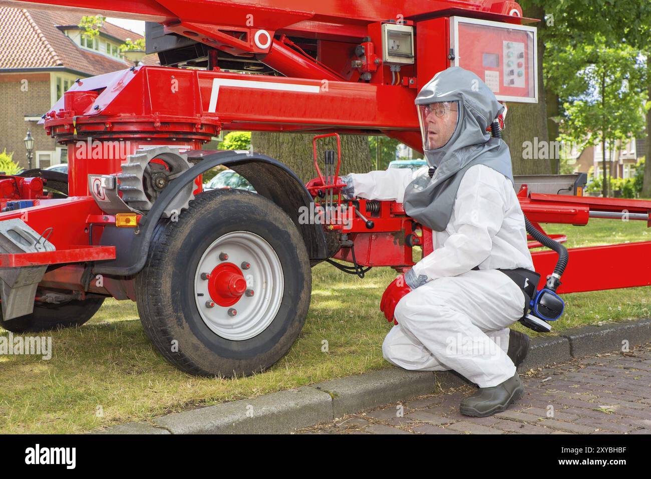 Insektenvernichter in schützende Arbeitskleidung betreibt Seitenstapler Stockfoto