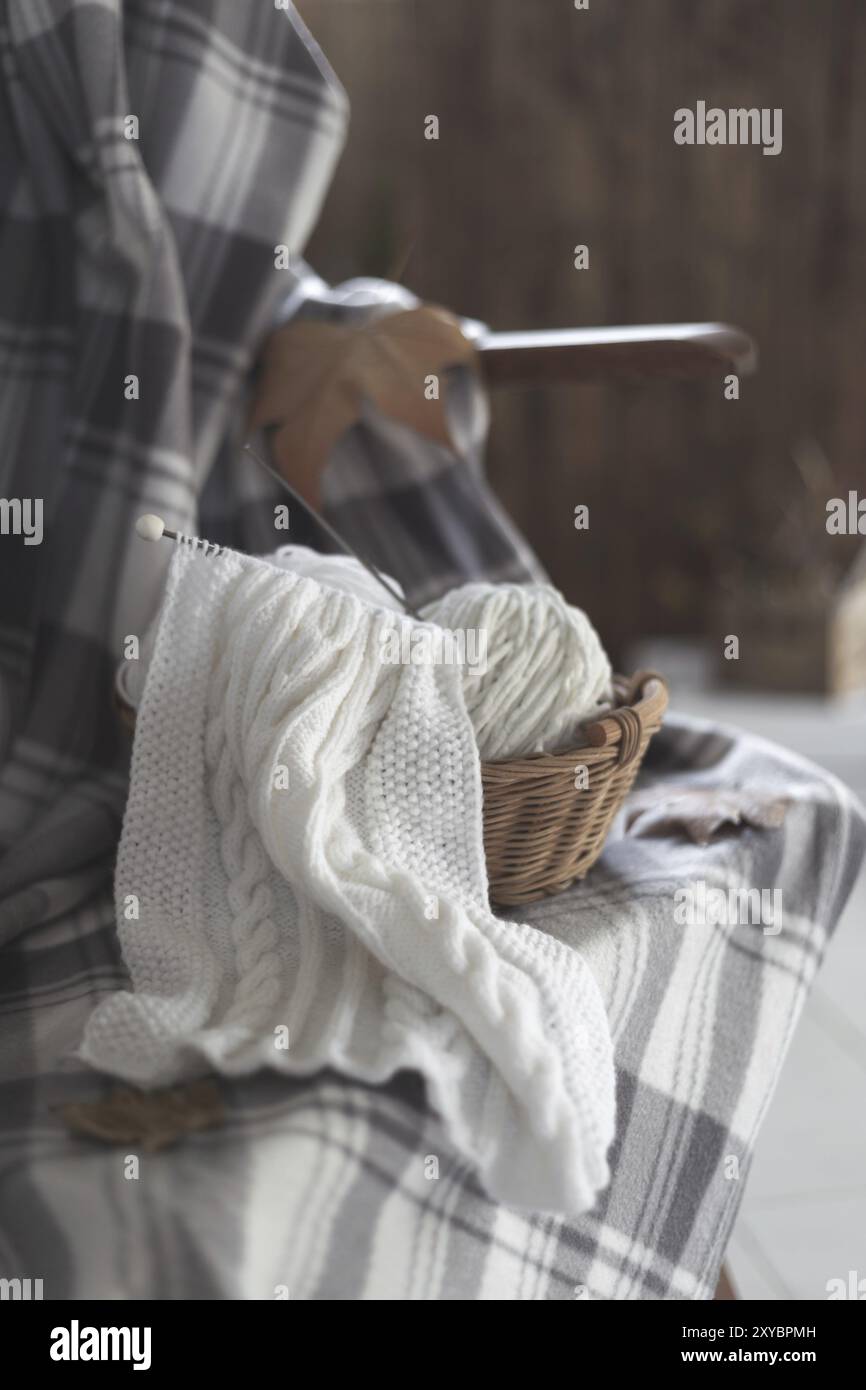Kugeln aus weißem Garn in einem Korb mit Stricknadeln herbst Konzept Stockfoto