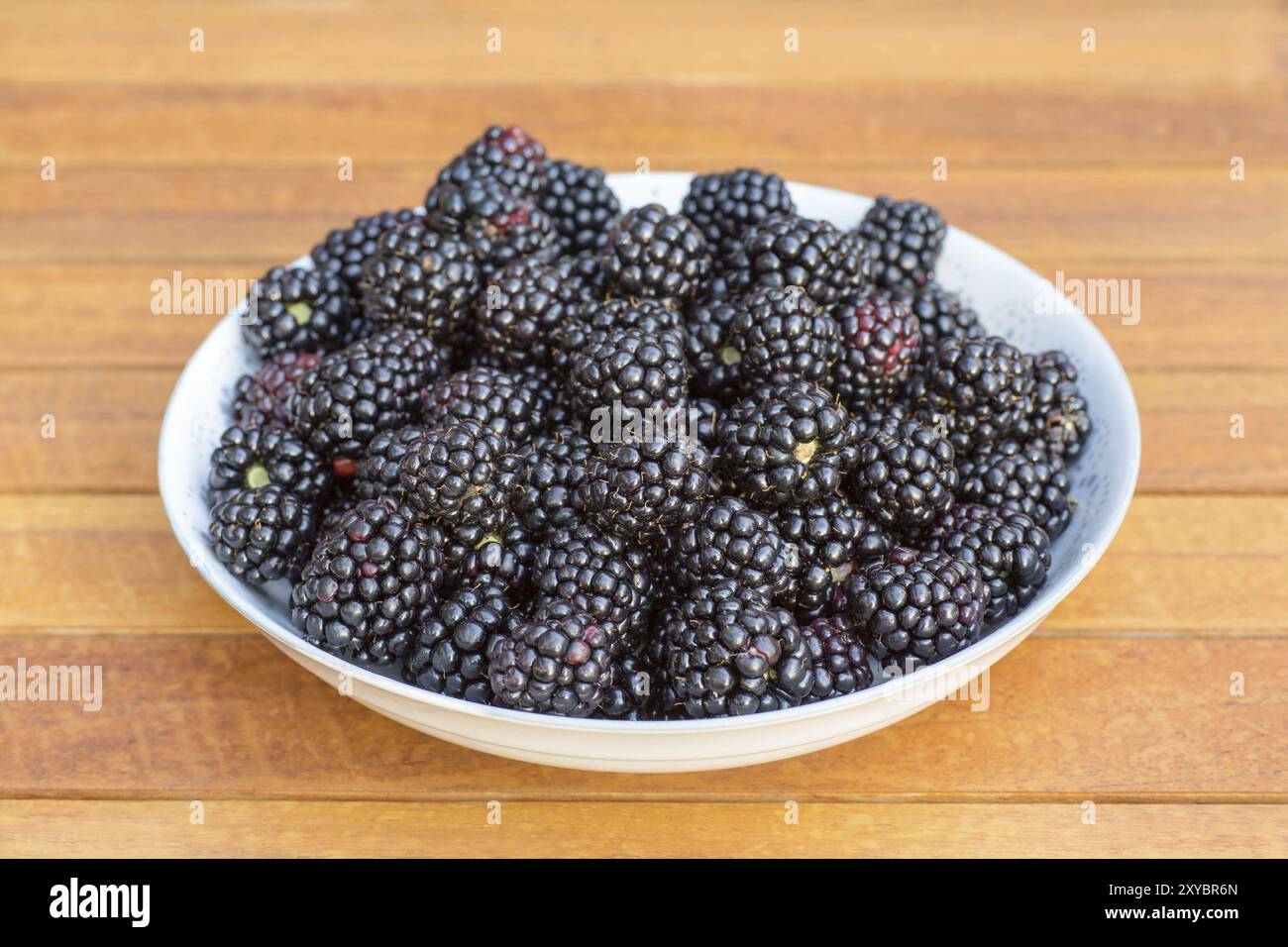 Maßstab voller Reife Brombeeren auf hölzernen Tisch Teak Stockfoto