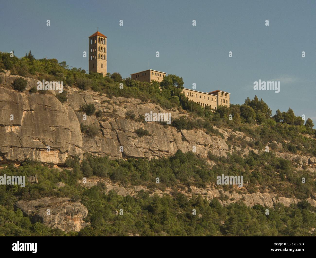 Kloster auf einem Felsen, umgeben von Bäumen unter klarem Himmel, montserrat, spanien Stockfoto