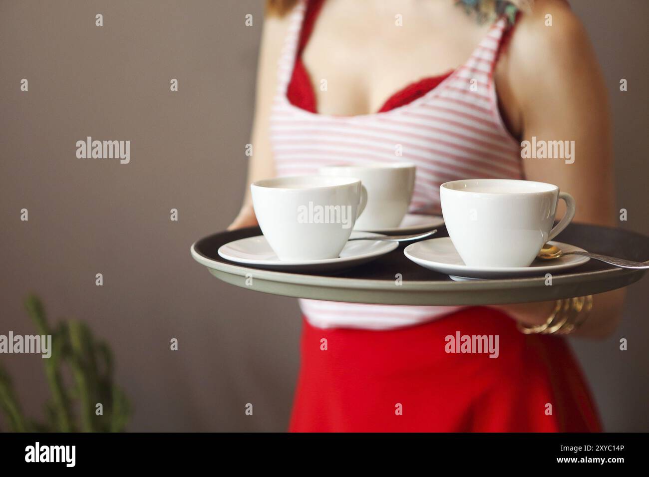 Schöne junge Frau tragen helle Kleidung holding Fach und Kaffee Stockfoto