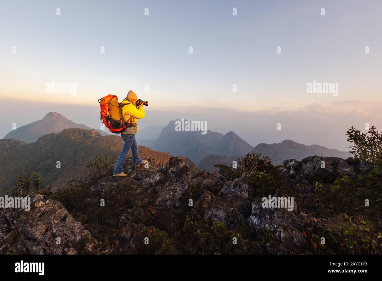 Naturfotografie-Konzept. Professioneller Naturfotograf, der Fotos im Hintergrund des Sonnenuntergangs in den Bergen macht. Wandern, Pho nehmen Stockfoto