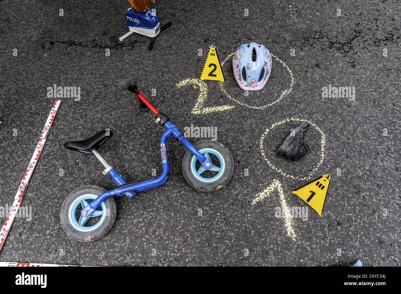 Markierungen an einem Unfallort mit Kinderwaagerad, Helm, nachgeahmter Unfallaufzeichnung, bei einer öffentlichen Veranstaltung der Kölner Polizistin Stockfoto