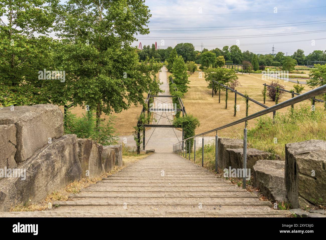 Gelsenkirchen, Nordrhein-Westfalen, Deutschland, 25. Juli 2018: Treppen, die zu einem Fußweg durch eine geröstete Wiese im Nordsternpark führen Stockfoto