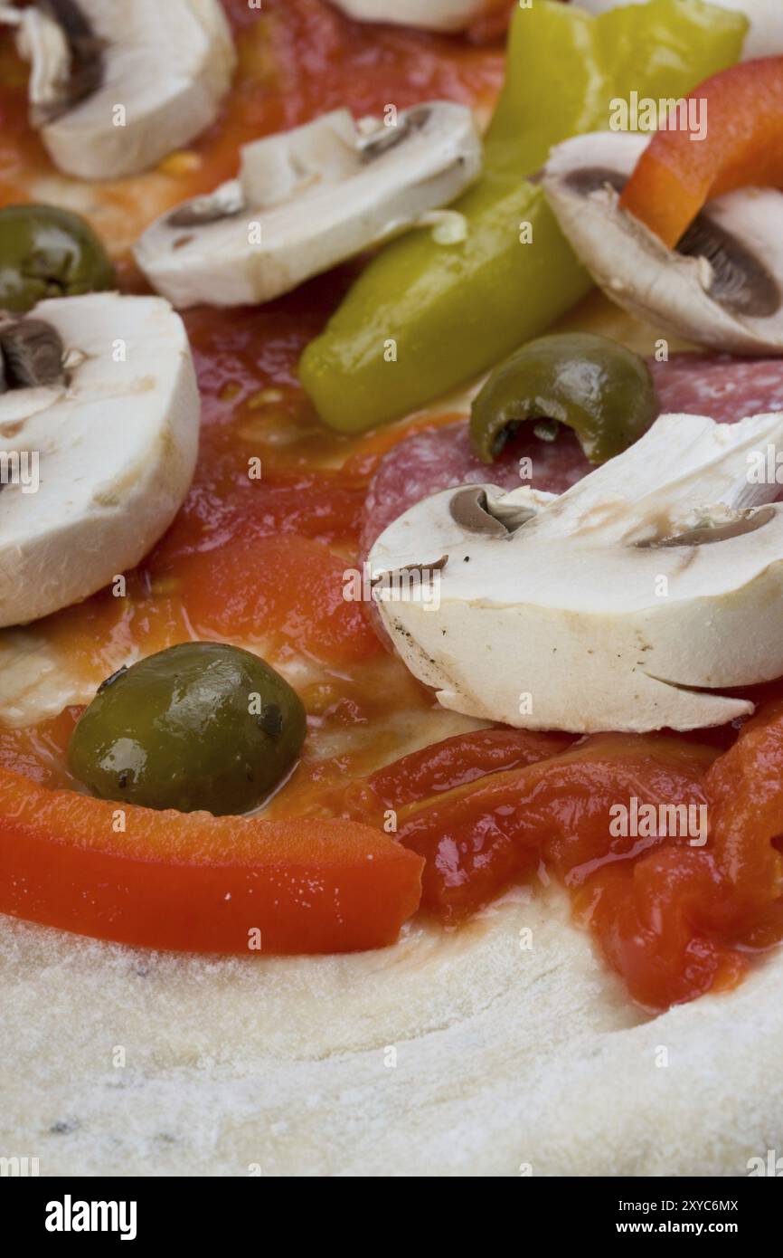 Ungebackene Pizza, zubereitet zum Backen auf einem Holzbrett Stockfoto