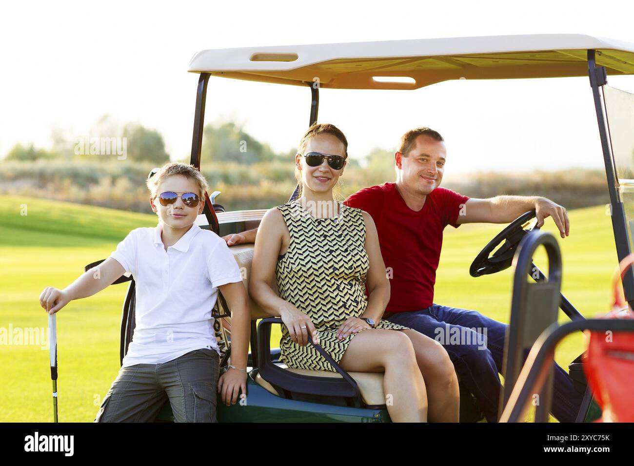 Glücklich Familienporträt in einem Wagen auf dem Golfplatz Stockfoto