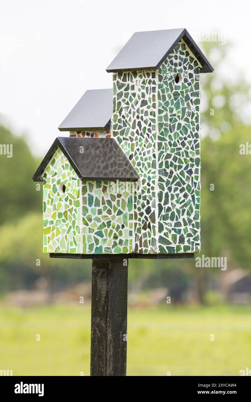 Nistkästen mit Mosaikfliesen auf Pole außerhalb Stockfoto