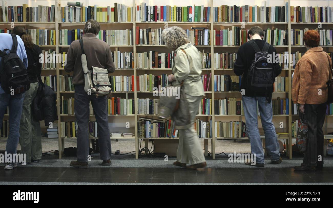 Leute vor vollen Bücherregalen Stockfoto