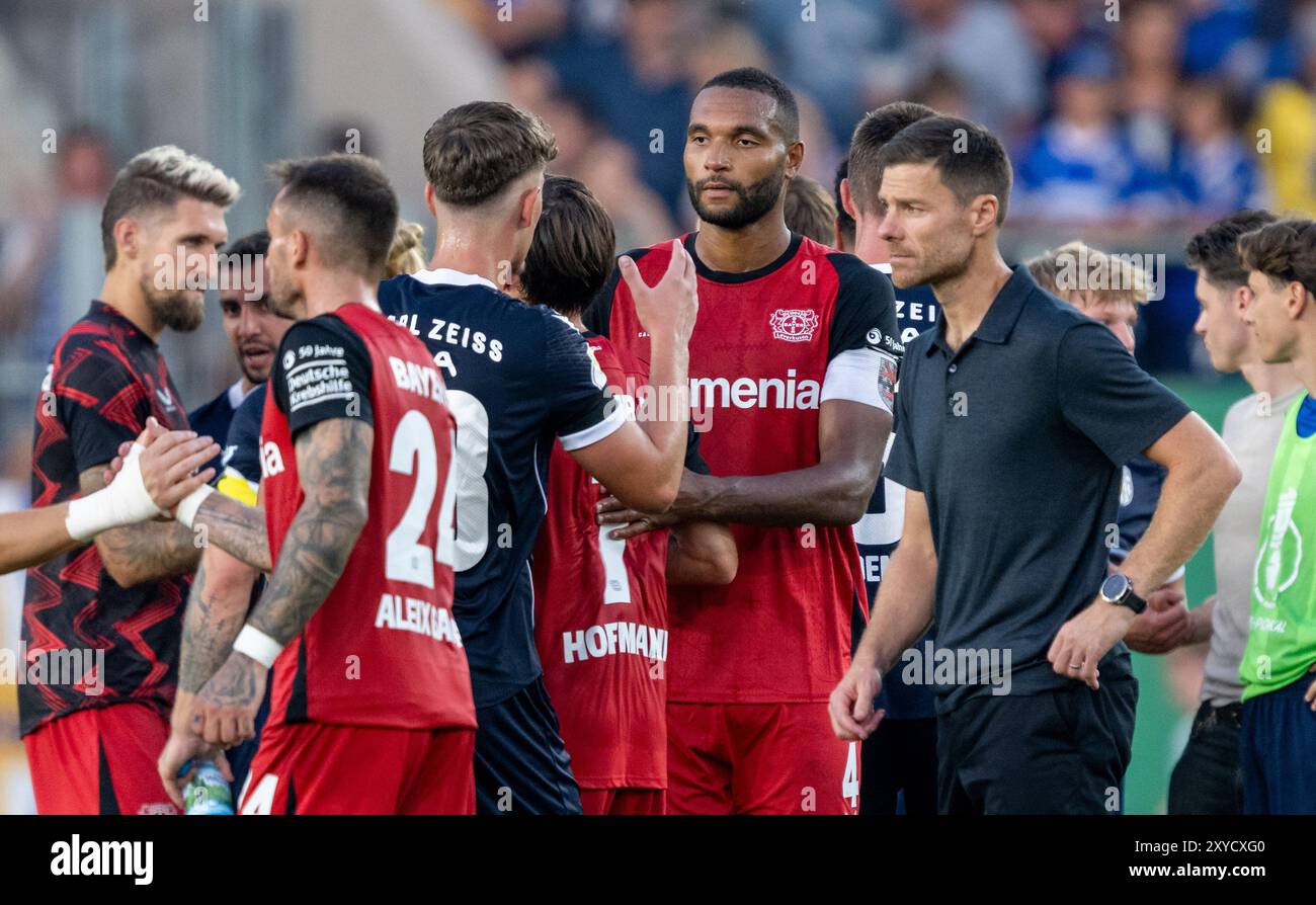 Jena, Deutschland. August 2024. Fußball: DFB-Cup, FC Carl Zeiss Jena - Bayer 04 Leverkusen, 1. Runde, Ernst-Abbe-Sportfeld. Leverkusens Team mit Trainer Xabi Alonso (von rechts) und Kapitän Jonathan Tah reagieren nach dem Spiel. Hinweis: Hendrik Schmidt/dpa - WICHTIGER HINWEIS: Gemäß den Vorschriften der DFL Deutschen Fußball-Liga und des DFB Deutschen Fußball-Bundes ist es verboten, im Stadion und/oder des Spiels aufgenommene Fotografien in Form von sequenziellen Bildern und/oder videoähnlichen Fotoserien zu verwenden oder zu verwenden./dpa/Alamy Live News Stockfoto