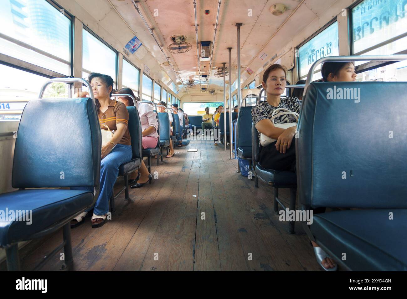 Bangkok, Thailand, 4. April 2007: Thailändische Passagiere fahren in einem nicht überfüllten Stadtbus mit Holzböden im Inneren, Asien Stockfoto