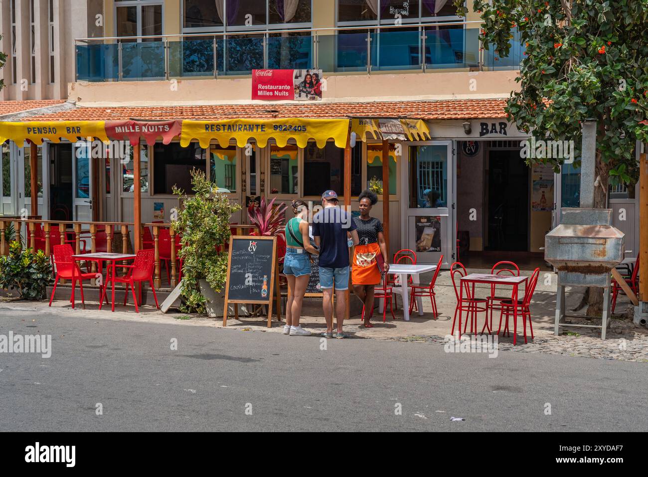 Tarrafal, Kap Verde - 10. Juni 2024: Blick auf die Stadt Tarrafal mit Touristen auf der Straße, die ein Menü aus einem Restaurant auf der Insel Kap Verde suchen Stockfoto
