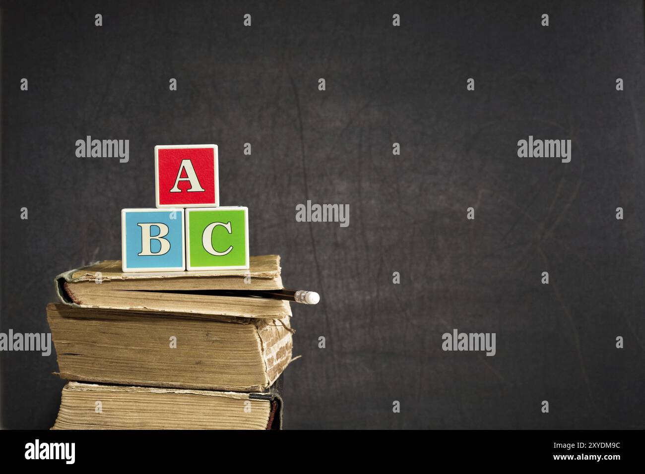 ABC auf alten Lehrbüchern gegen Tafel im Klassenzimmer Stockfoto