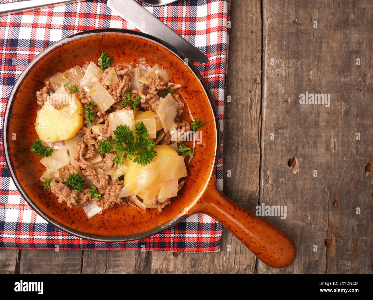 Weißkohl mit gebratenem Rindfleisch und Kartoffeln in einem keramischen Pfanne, saisonale Gerichte Stockfoto