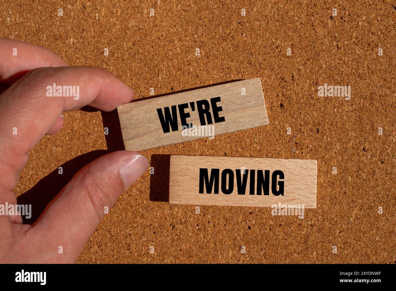 Wir bewegen eine Botschaft auf Holzblöcken mit braunem Hintergrund. Begriffliches Symbol, dass wir uns bewegen. Kopierbereich. Stockfoto
