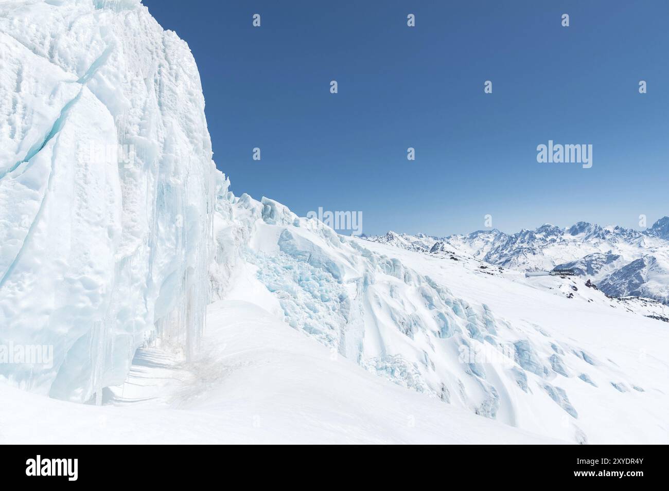 Ein großer schneebedeckter Gletscher hoch in den Bergen vor dem Hintergrund des Kaukasus-Gebirges und des blauen Himmels Stockfoto