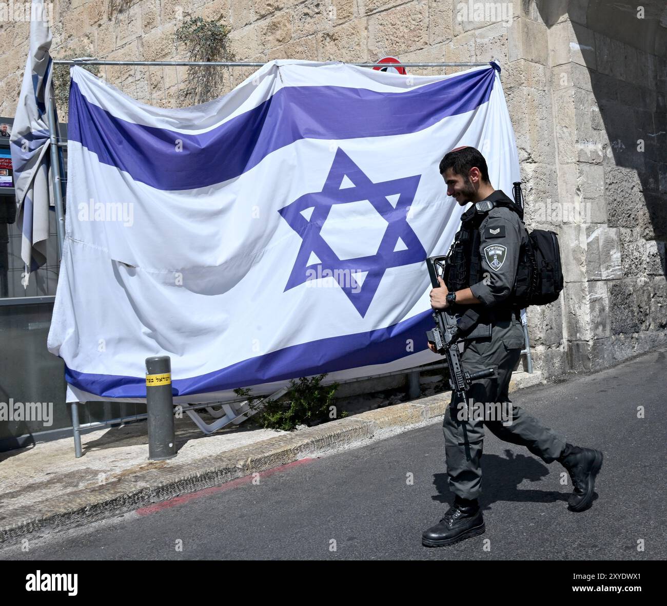 Jerusalem, Israel. August 2024. Eine israelische Grenzpolizei patrouilliert am Dung-Tor der Altstadt Jerusalems an einer Nationalflagge vorbei, die am Donnerstag, den 29. August 2024, zur südlichen Mauer des Tempelberges und zur Westmauer in Jerusalem führt. Foto: Debbie Hill/ Credit: UPI/Alamy Live News Stockfoto