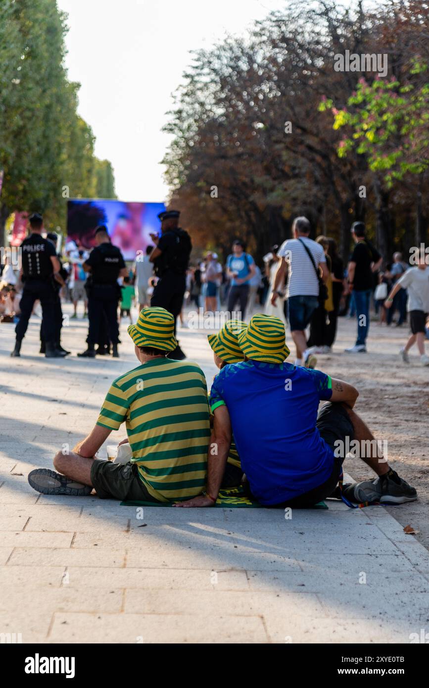 Paris, Frankreich. August 2024. Drei brasilianische Fans warten auf die Eröffnungszeremonie der Paralympischen Spiele 2024 in Paris auf der Avenue des Champs-Elysées. Quelle: Fabienne Koch/Alamy Live News Stockfoto