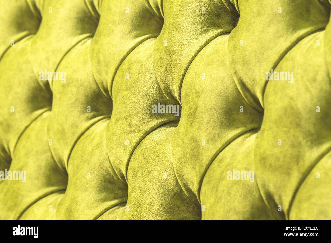 Veloursoberfläche der Close-up-Couch. Trainingsausrüstung - Velormatten mit Knöpfen festgezogen. Gelber chesterfield-Stil gesteppter Polsterhintergrund Nahaufnahme Stockfoto