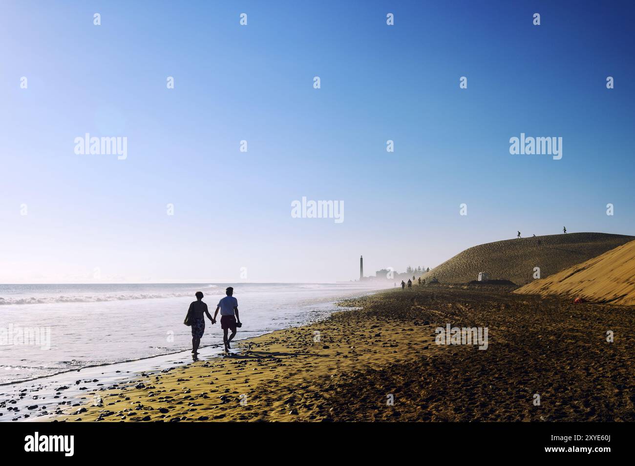 Ein Paar, das einen Abendspaziergang am Strand in Maspalomas macht Stockfoto