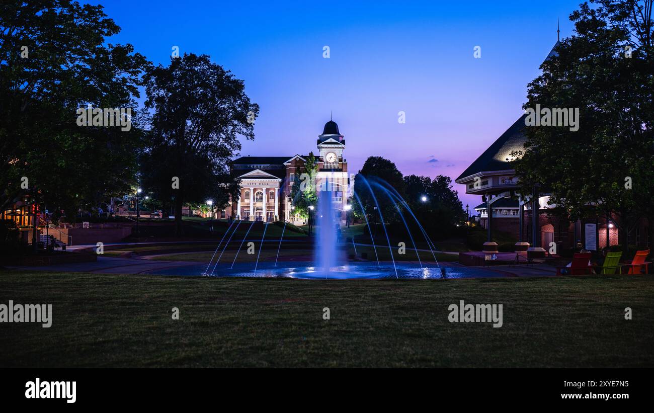 Ein beleuchteter Blick auf das Rathaus in der Stadt Duluth in Georgia, aufgenommen bei Sonnenuntergang mit einem Brunnen im Vordergrund Stockfoto