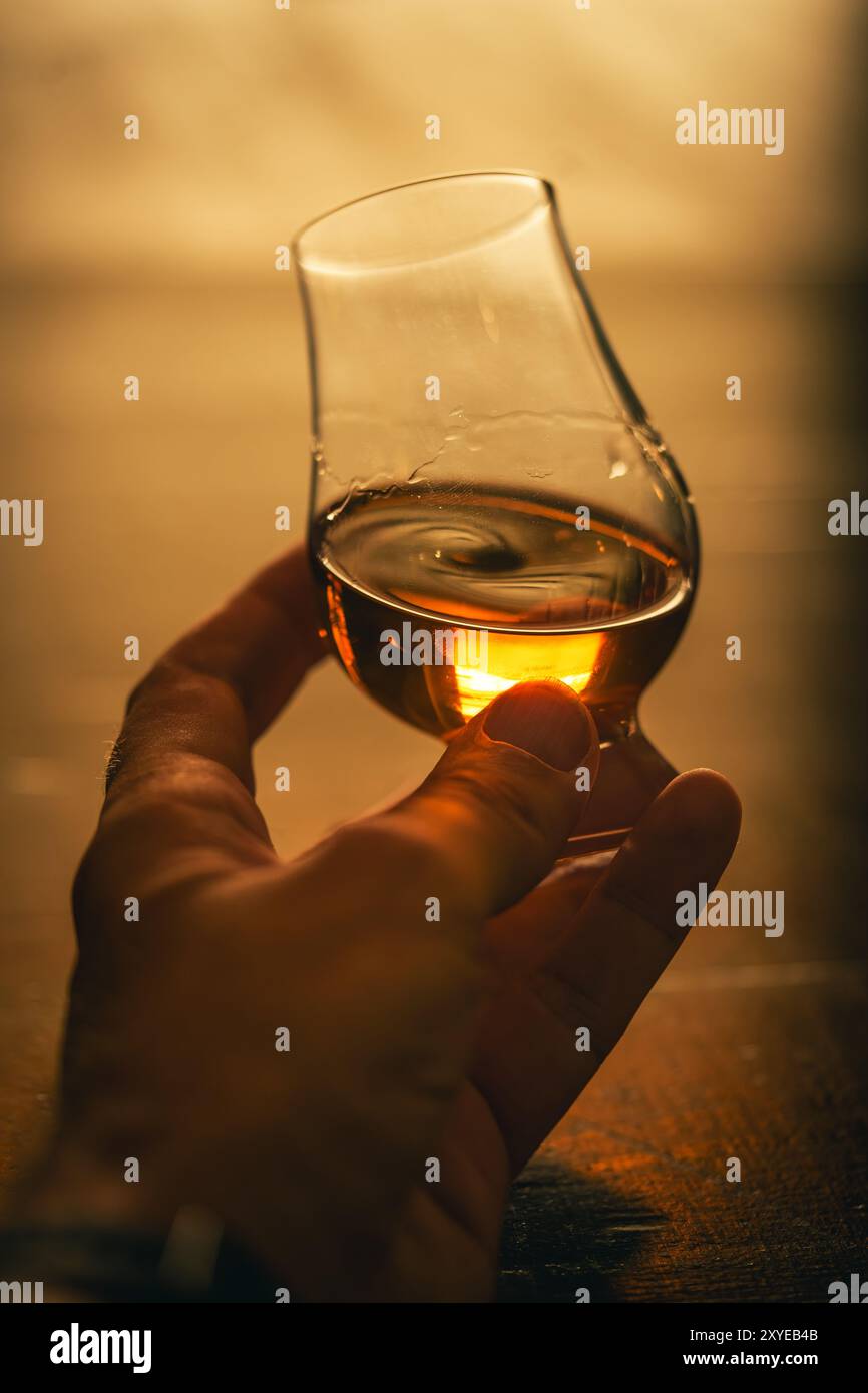 Farb-Nahaufnahme einer Hand, die ein einzelnes Glencairn Whiskyglas hält. Stockfoto