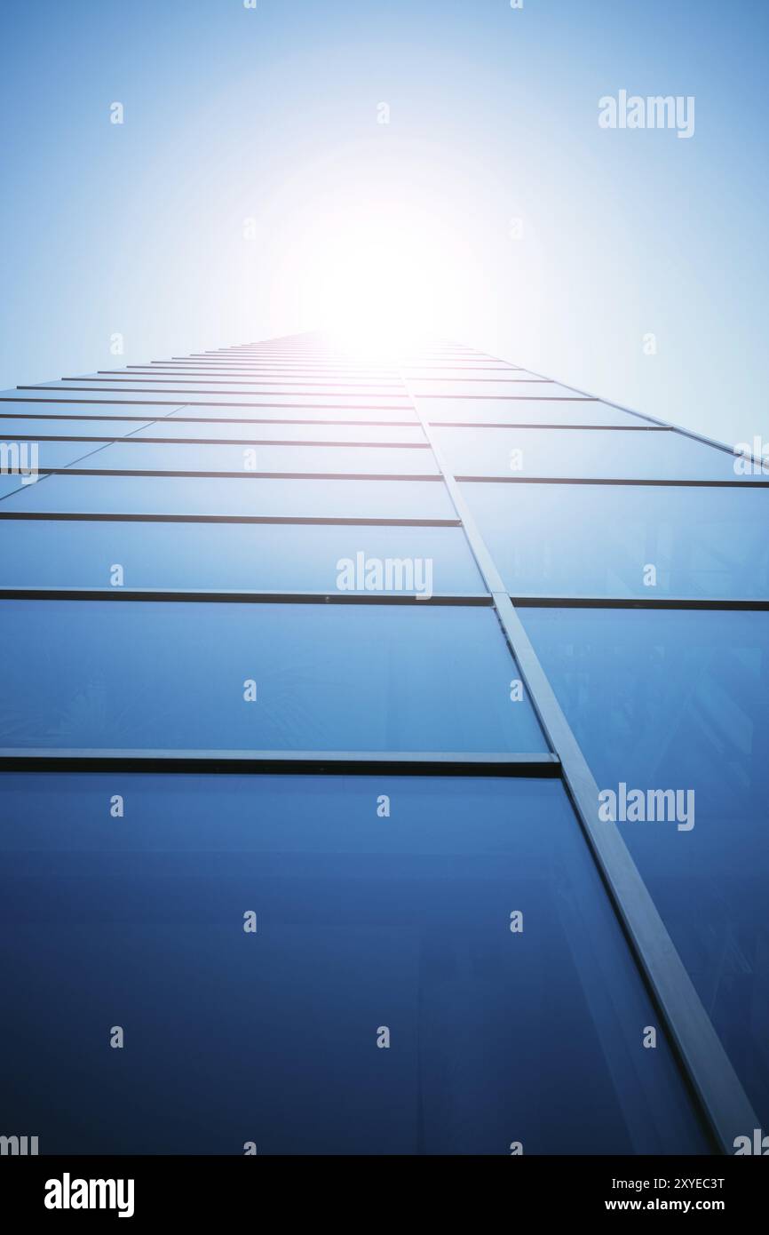 Moderner Wolkenkratzer aus Glas, blauem Himmel und Sonnenstrahl Stockfoto