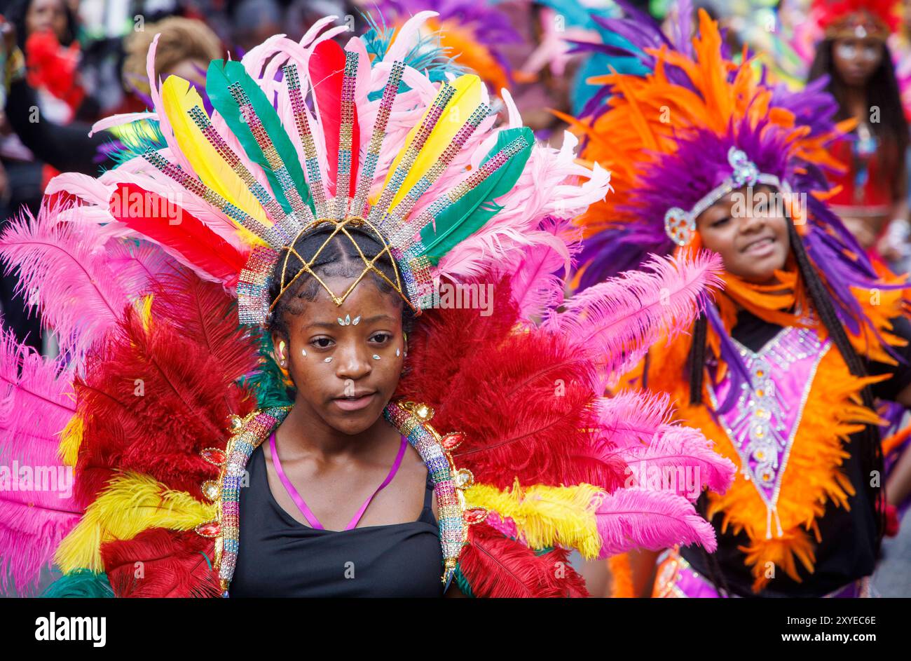 Künstler und Tänzer in traditionellen Kostümen feiern den Karibischen Karneval in Notting Hill, der am Wochenende der Feiertage im August stattfindet. Stockfoto