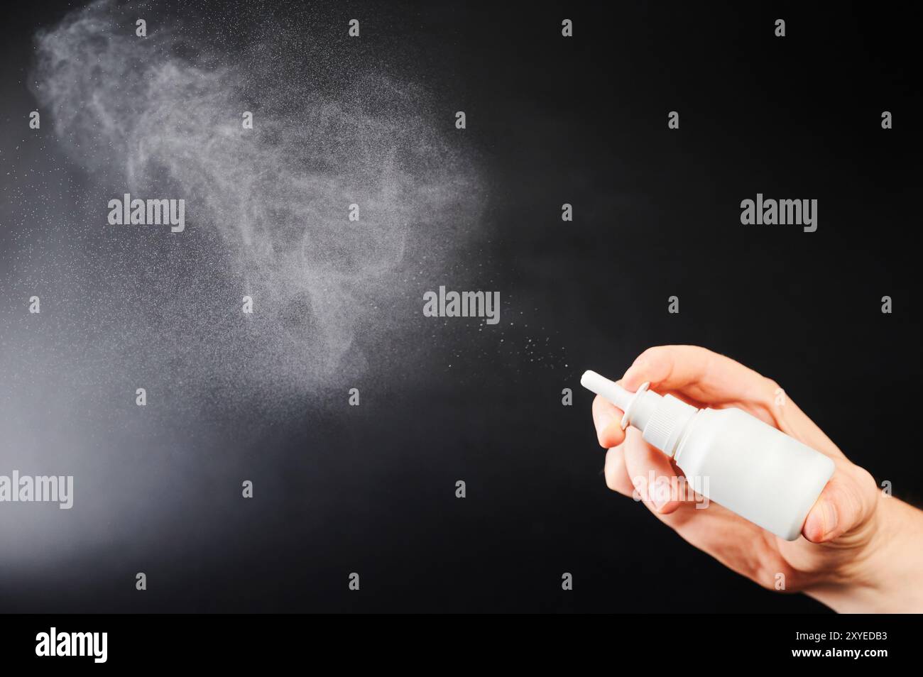 Nahaufnahme der Hand mit Nasenspray isoliert auf schwarzem Studiohintergrund Stockfoto