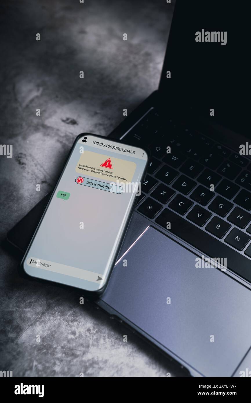 Smartphone, das auf dem Laptop liegt, empfängt eine Nachricht von mutmaßlichem Zahlenbetrug. Unerwünschter anonymer Anruf. Betrugs- und Phishing-Telefonkonzept. Nachricht von Fremdem. Stockfoto