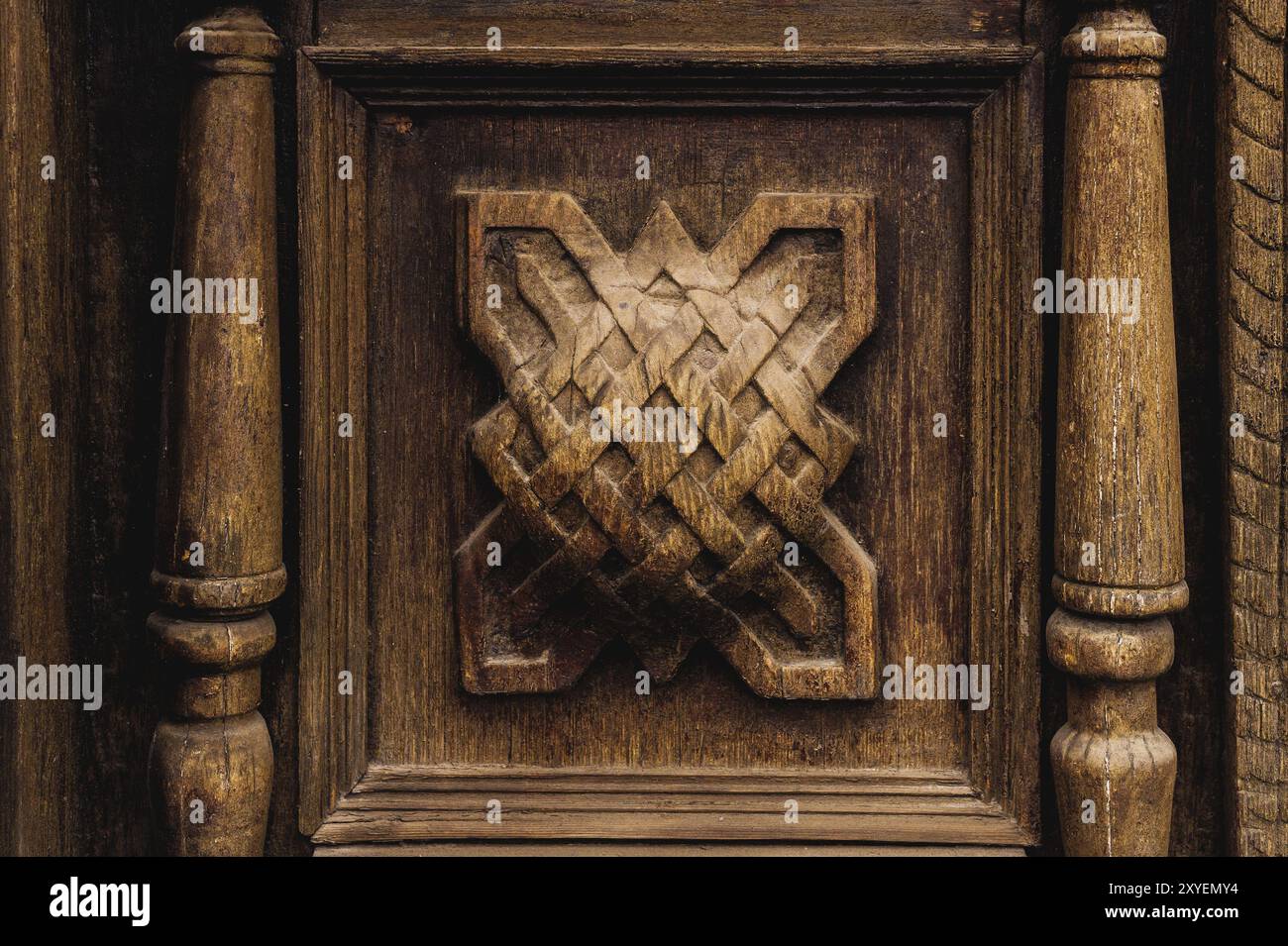 Vintage-Hintergrund. Elemente einer alten geschnitzten Holztür mit voluminösen geschnitzten Holzelementen, die die Webkunst imitieren. Ein Vintage-Konzept von Stockfoto