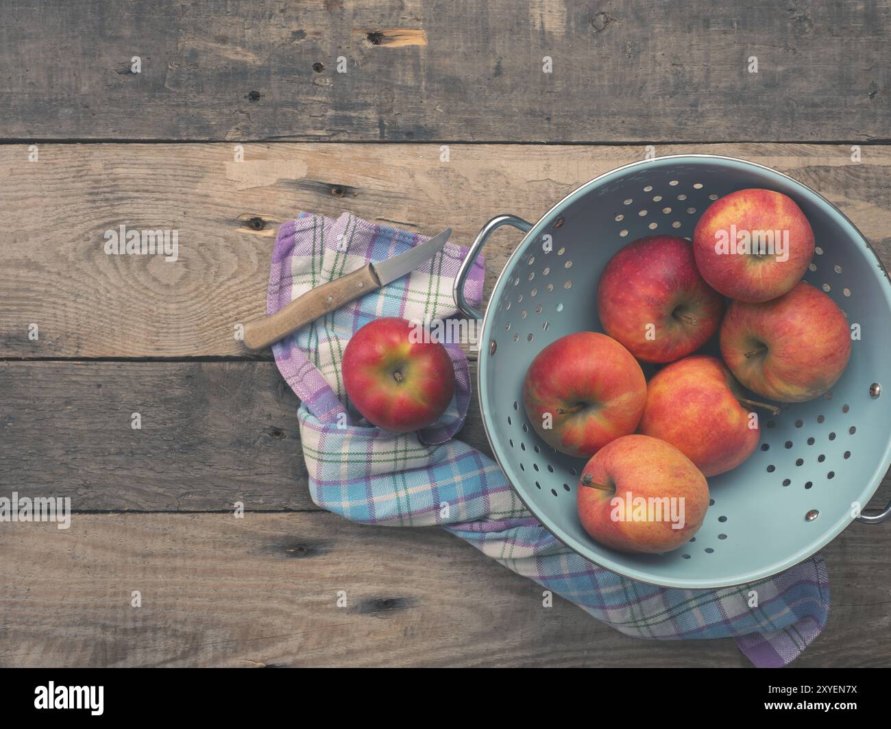 Köstliche Bio-äpfel in einem alten verwendet Sieb auf einem rustikalen Holztisch, Flachbild Ton vintage Stil mit Blick von oben Stockfoto