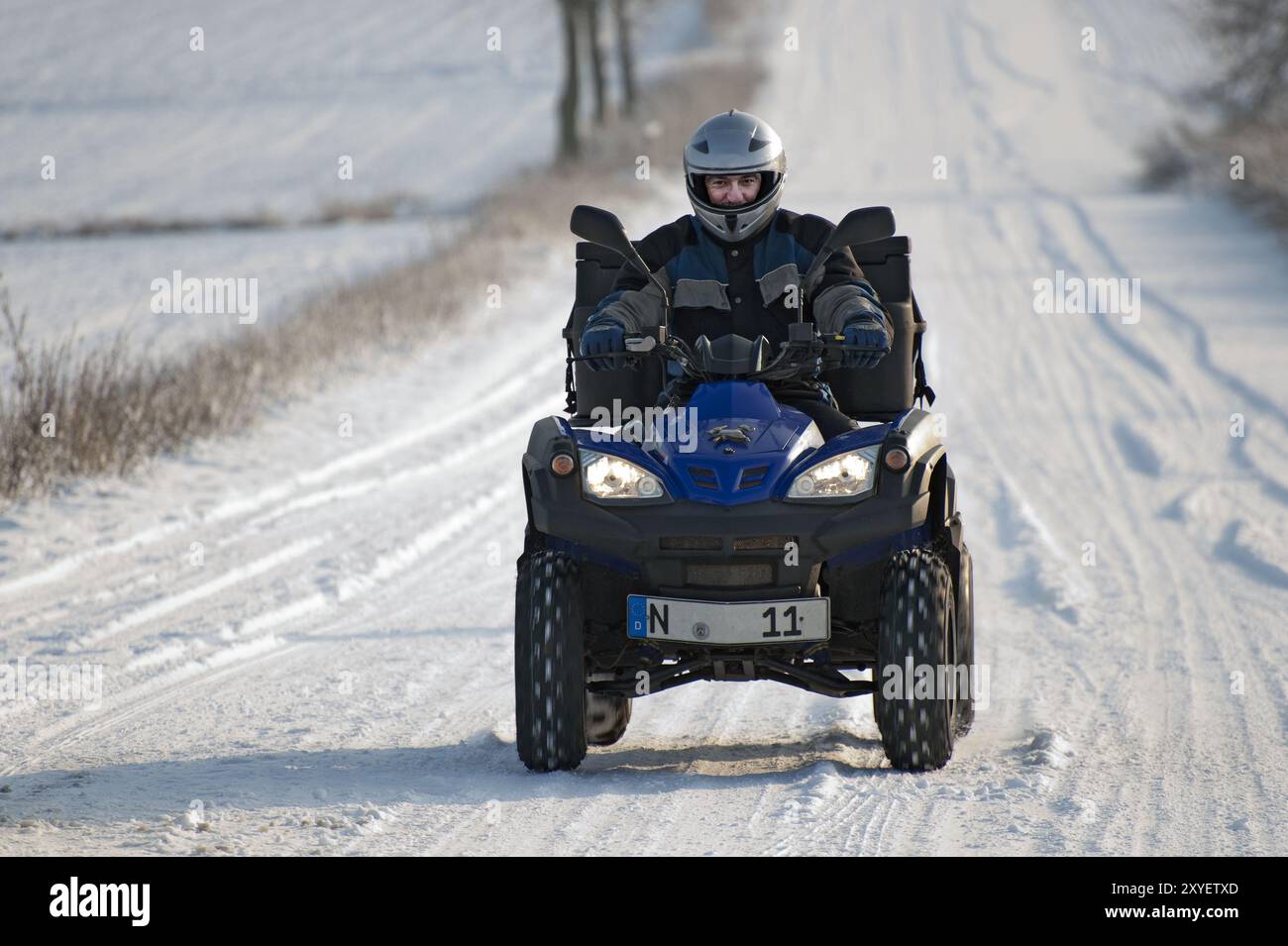Aktive Senioren fahren im Winter mit einem Quad Stockfoto