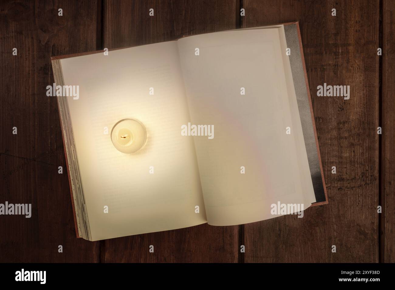 Ein Mock-up eines offenen altes Buch mit einer brennenden Kerze, Lesen im Dunkeln Design Template mit einem Platz für Text Stockfoto