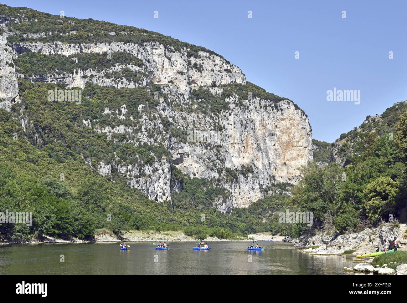 Flusslandschaft mit farbenfrohen Kanus, Wald am Ufer, hohe Klippen Stockfoto