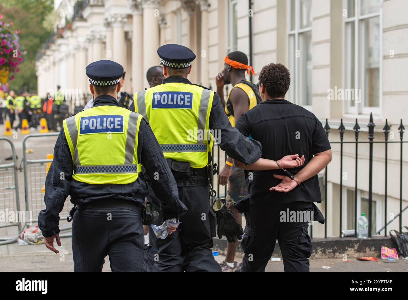 Die Polizei verhaftet einen Mann während der Erwachsenenparade des Notting Hill Karnevals und legt ihm Handschellen an. (Rechtliche und datenschutzrechtliche Fragen müssen vor der Verwendung überprüft werden) Stockfoto