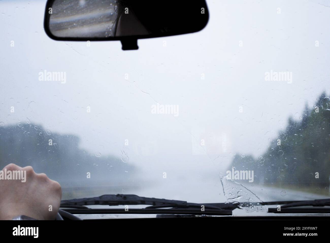 Blick durch die Windschutzscheibe auf der Autobahn bei regnerischem Wetter Stockfoto