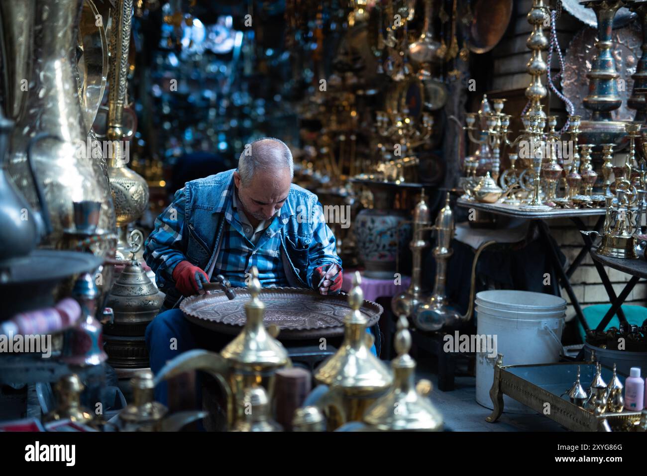 Handwerker veredeln eine Kupferplatte auf dem Kupfermarkt, bekannt als Souq al-Safafeer in Bagdad, Irak - 12. Dezember 2018 Stockfoto