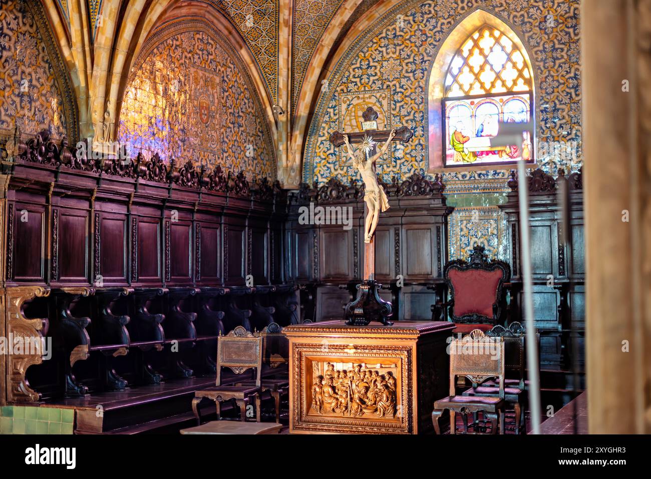 SINTRA, Portugal – die Kapelle des Pena-Palastes, ursprünglich Teil des frühen Klosters der Hieronymiten-Mönche, zeigt einen Alabaster-Retabel aus dem 16. Jahrhundert von Nicolau Chanterene. Das gotische Kirchenschiff ist mit Spitzbögen und monochromen Fliesen aus dem 16. Jahrhundert geschmückt, während Apsis und Chor mit gewölbten, mit polychromen Fliesen aus dem 17. Jahrhundert gesäumten Bögen bedeckt sind. Die Kapelle wurde später von König Ferdinand II. Als seine pfälzerkapelle genutzt. Stockfoto