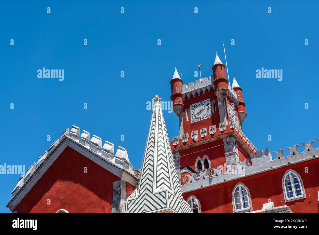 SINTRA, Portugal – der prunkvolle rote Turmglockenturm des Pena Palace hebt sich vom Himmel ab und zeigt die lebhaften Farben und die eklektische romantische Architektur dieser königlichen Residenz aus dem 19. Jahrhundert. Diese Besonderheit verkörpert den märchenhaften Charme, der Pena Palace zu einem Wahrzeichen in Sintra macht. Stockfoto