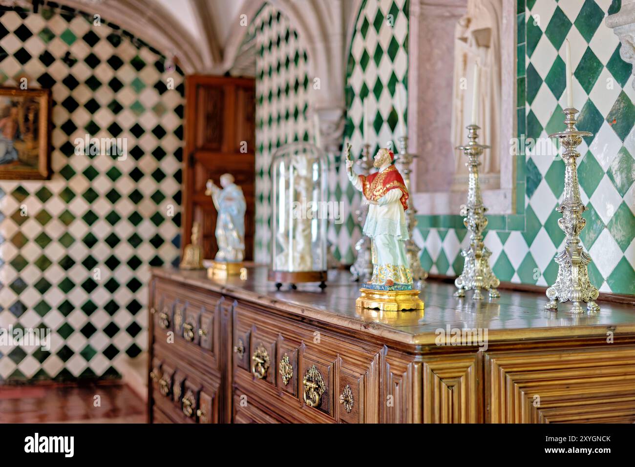 Pena Palace Interior Dekorative Elemente Sintra Portugal // SINTRA, Portugal — Dekorative Elemente im Pena Palace, einem romantischen Schloss aus dem 19. Jahrhundert in Sintra, Portugal. Das Innere des Palastes zeigt eine Mischung aus architektonischen Stilen und kunstvollen Details, einschließlich aufwendiger Wanddekorationen, komplizierter Decken und Stilmöbel. Pena Palace, ein UNESCO-Weltkulturerbe, ist bekannt für sein vielseitiges Design und seine reiche historische Bedeutung. Stockfoto