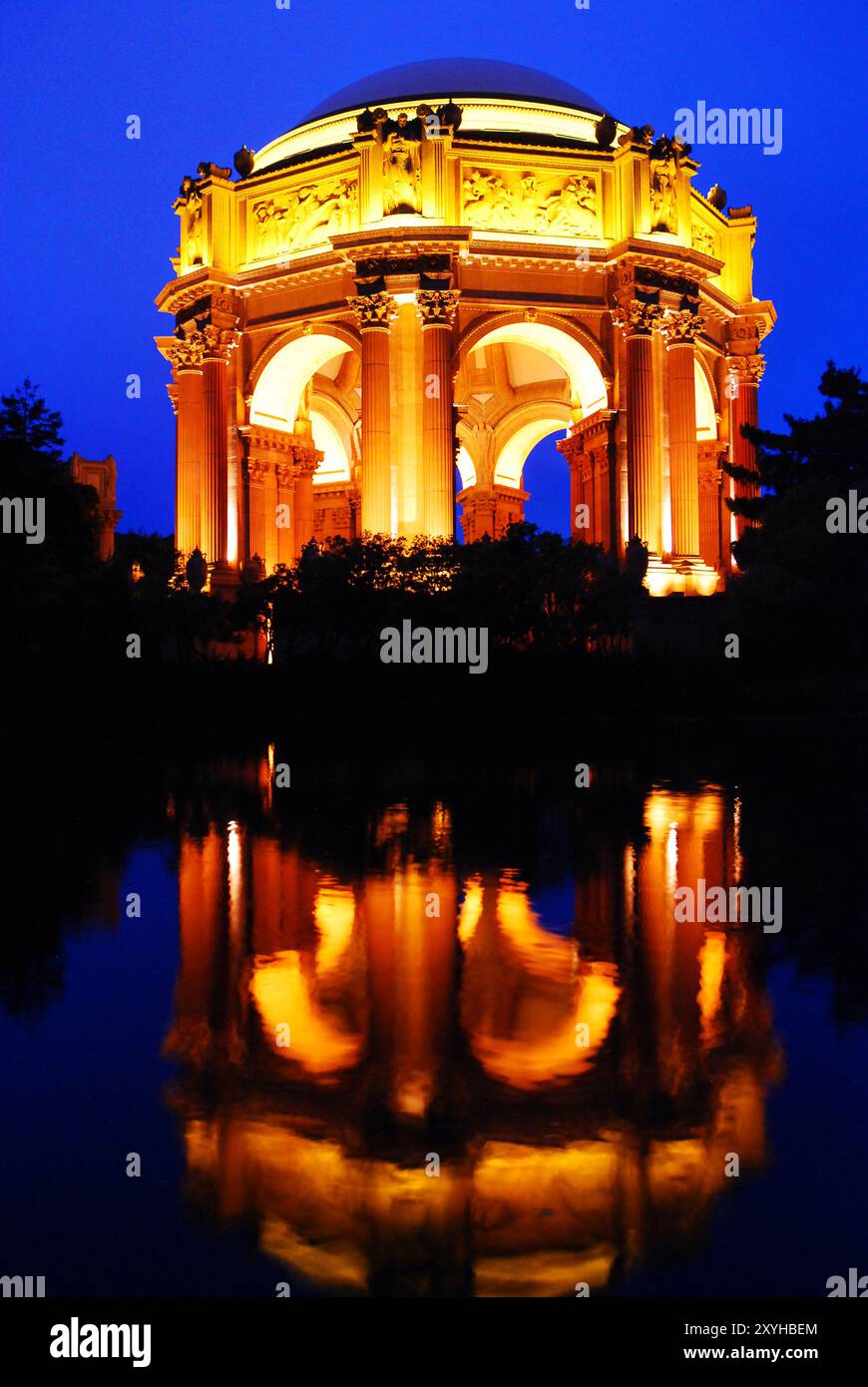 Der Palast der Schönen Künste in San Francisco wird nachts beleuchtet und spiegelt sich im ruhigen Wasser des Parks wider Stockfoto