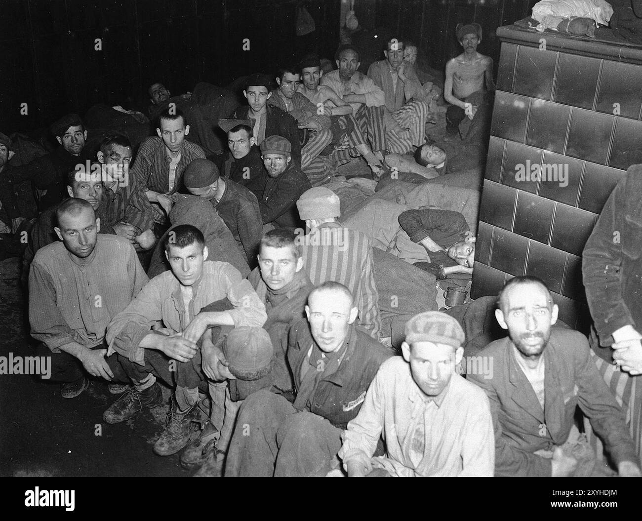 Überlebende in Dachau nach der Befreiung. Dachau war das erste Konzentrationslager der nazis, das am 22. März 1933 eröffnet wurde (nur sieben Wochen nach der Machtergreifung Hitlers). Obwohl es ein Zwangsarbeitslager war und es dort keine Gaskammern gab, waren Brutalität und gewalttätige Strafen die Norm. Dort gab es 32000 dokumentierte Todesfälle und viele Tausende weitere undokumentierte Todesfälle. Das Hauptlager (Dachau hatte 100 Unterlager) wurde am 29. April 1945 von der US-Armee befreit. Stockfoto