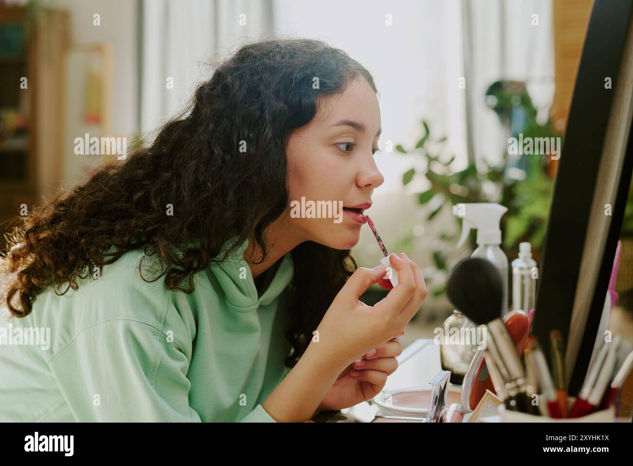 Lippenstift im Schlafzimmerspiegel mit fokussiertem Ausdruck auftragen Stockfoto