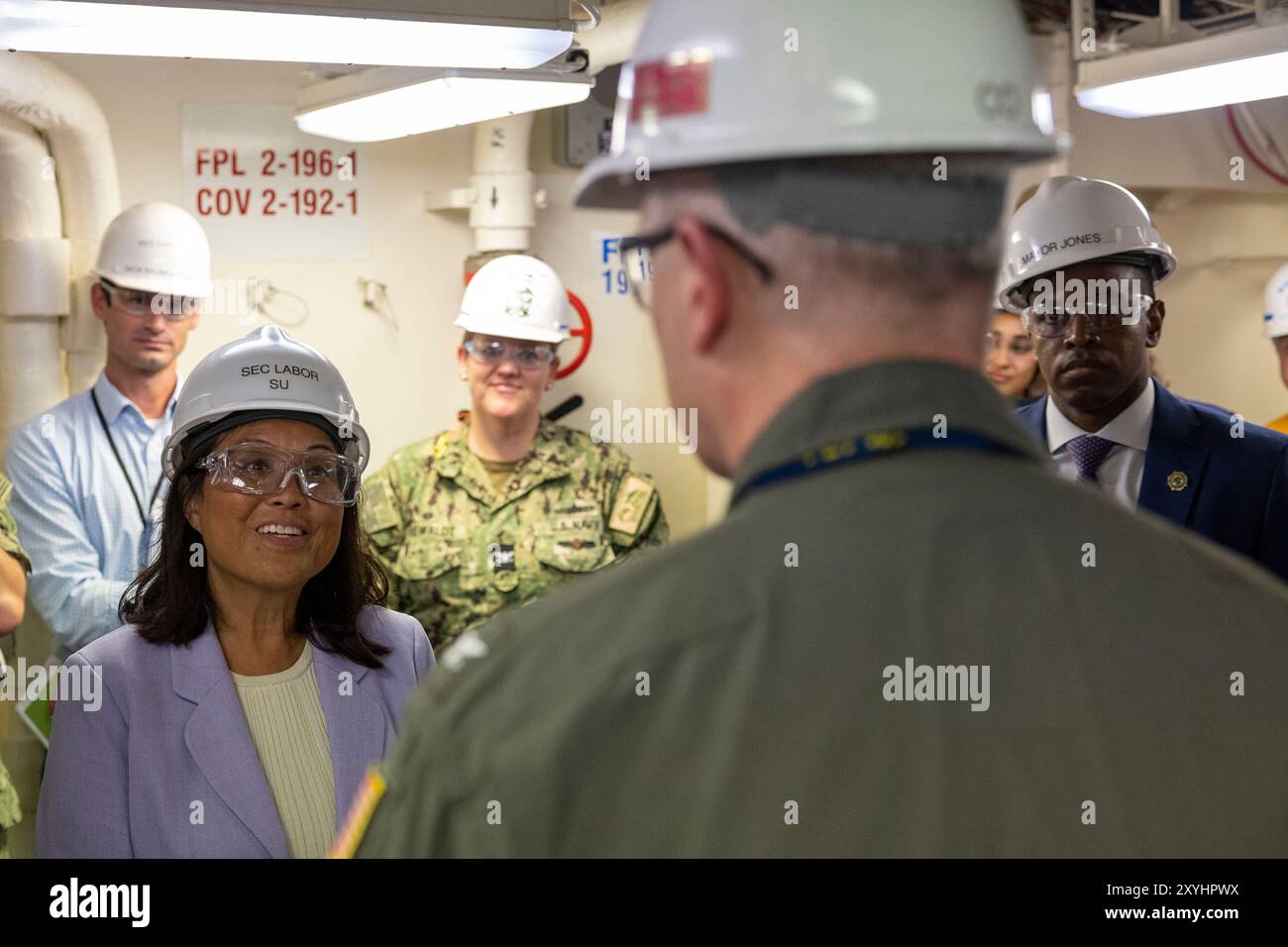 NEWPORT NEWS, Virginia (28. August 2024) - die amtierende Arbeitsministerin Julie Su, links, spricht mit Kapitän Colin P. Day, Kommandant des Ford-Klasse-Flugzeugträgers Pre-Commissioning Unit John F. Kennedy (CVN 79), während eines Schiffsbesuchs am 28. August 2024. Während des Besuchs erkannte Marineminister Carlos Del Toro, zusammen mit der amtierenden Arbeitsministerin Julie Su und dem Kongressabgeordneten Bobby Scott (VA-03), aus erster Hand, wie wichtig die maritimen Industriebasis für den Bau des technologisch fortschrittlichsten Flugzeugträgers der Gerald R. Ford-Klasse ist. John F. Kennedy ist der zweite Stockfoto