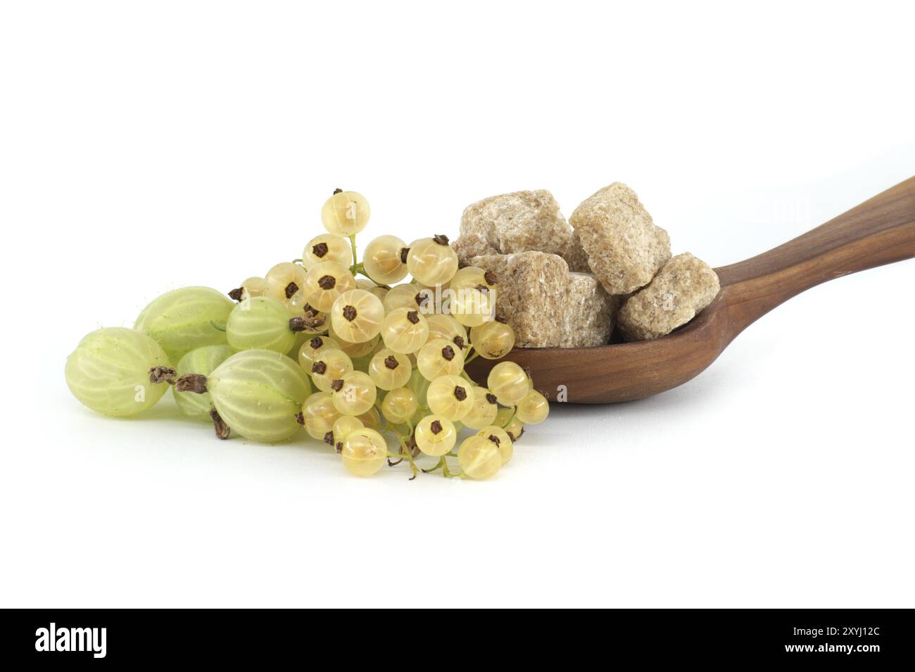 Stachelbeeren und gelbe Johannisbeeren neben braunen Rohrzuckerwürfeln in einer Holzschüssel, isoliert auf weißem Hintergrund, Beerenmarmelade, Kompottzubereitung Stockfoto