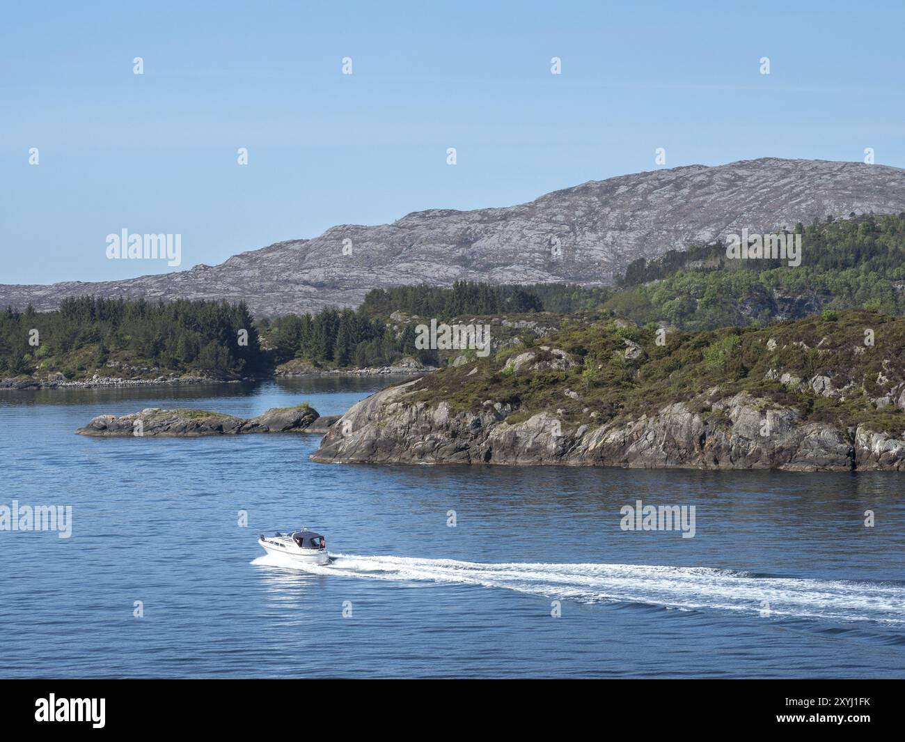 Ein Motorboot fährt entlang der norwegischen Inselküste Stockfoto