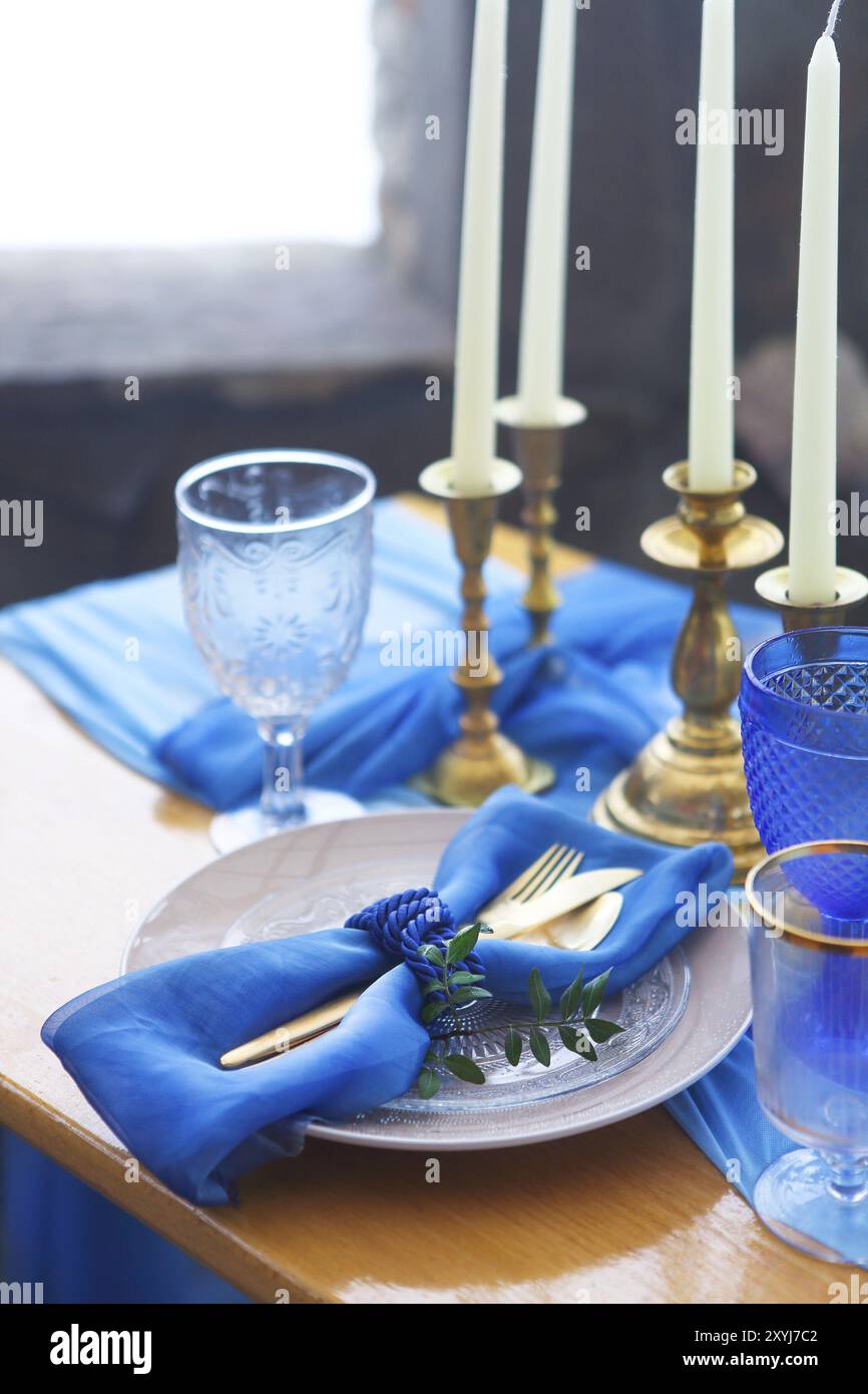 Tischdekoration im Vintage-Stil ist mit Kerzen in goldenen und blauen Farben dekoriert. Stockfoto