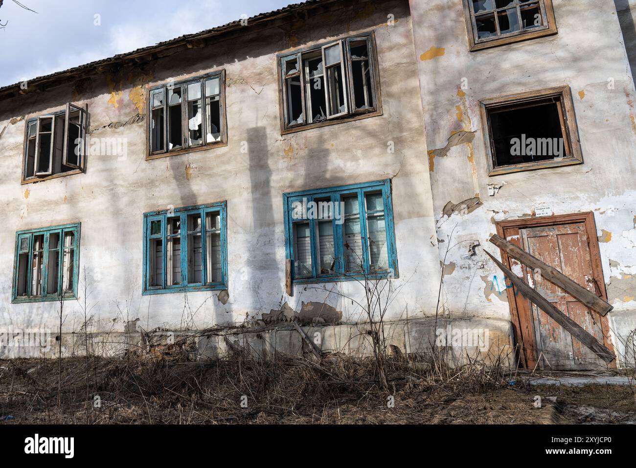 Ein altes verlassenes zweistöckiges Haus mit verschlossenen Fenstern und Türen Stockfoto